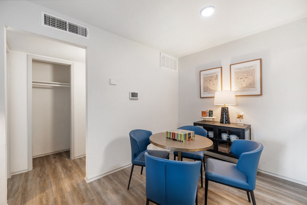a living room with a table and chairs and a refrigerator