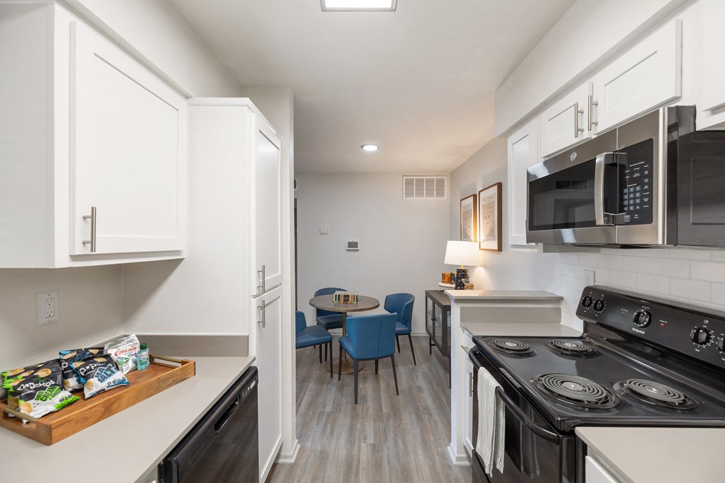 a kitchen with a stove and a microwave and a table with chairs
