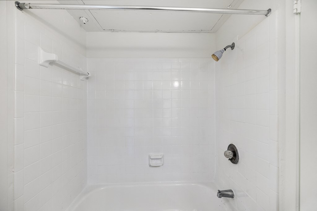 a white bathroom with a shower and a sink