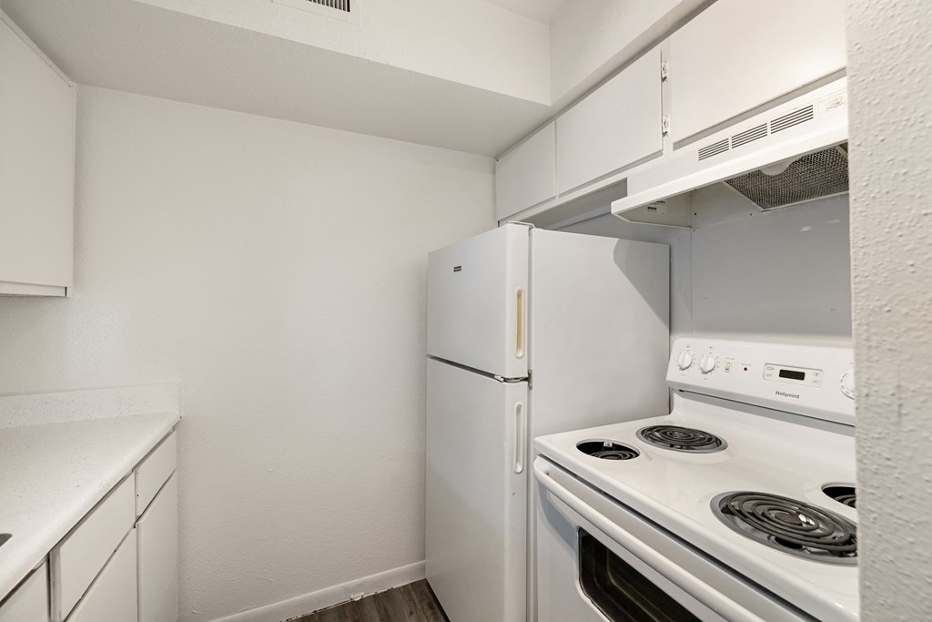 a kitchen with white appliances and a refrigerator
