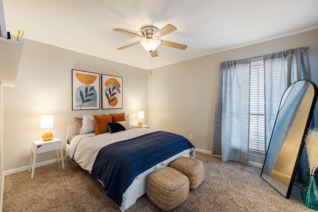 a bedroom with a large bed and a ceiling fan
