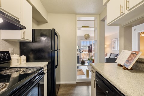 kitchen with black appliances and granite counter tops and a view of the living room