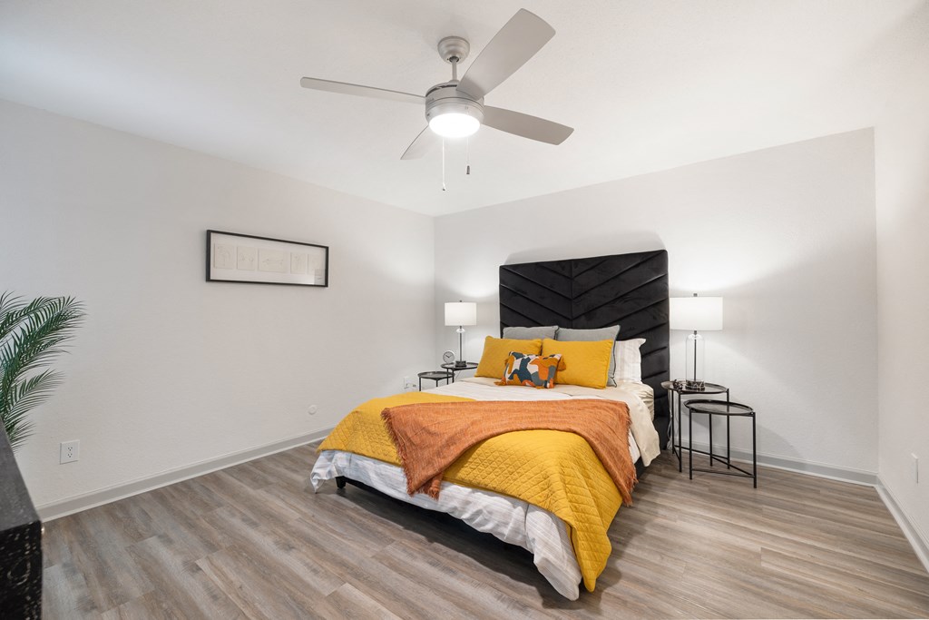 a bedroom with a bed and a ceiling fan