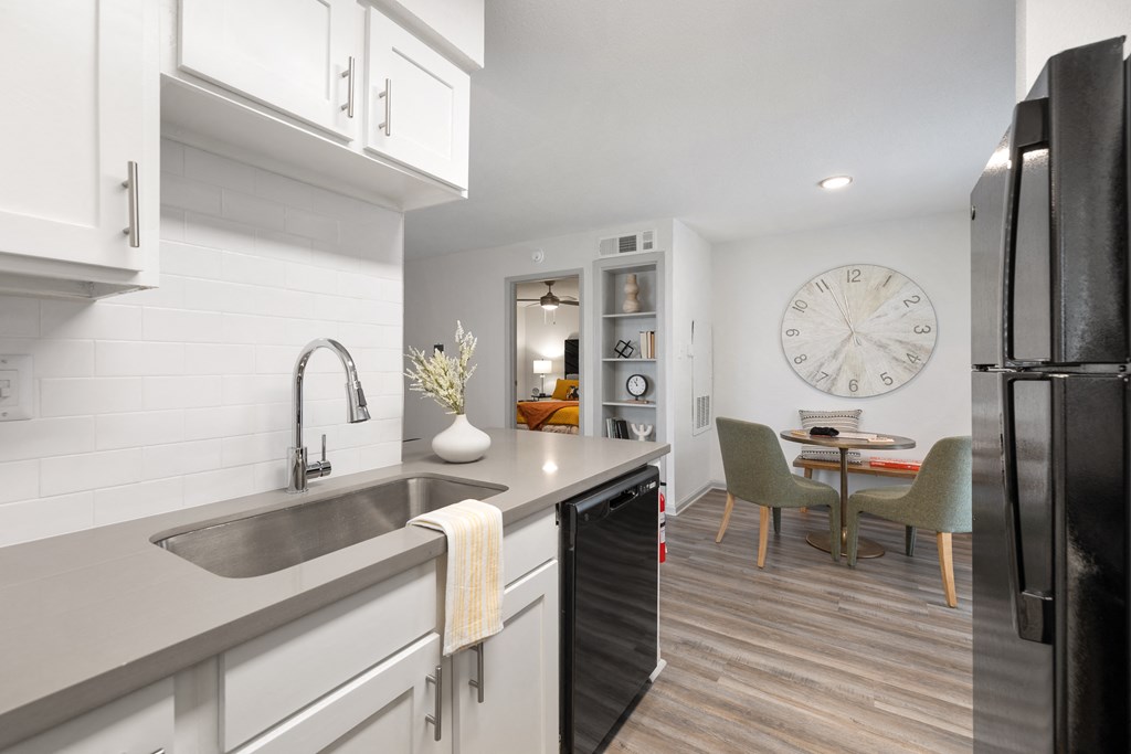 a kitchen with a sink and a large clock on the wall