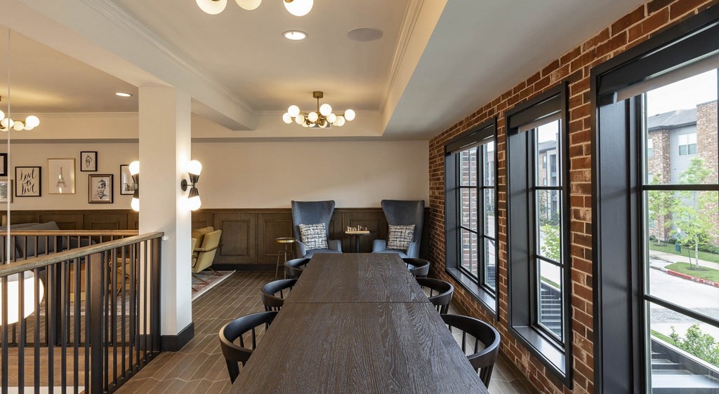 a dining room with a long table and chairs and windows