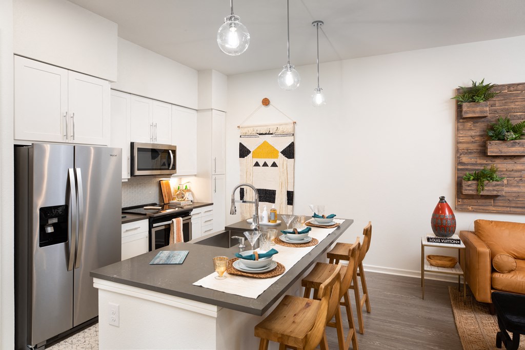 a kitchen and dining room with stainless steel appliances and a gray counter top