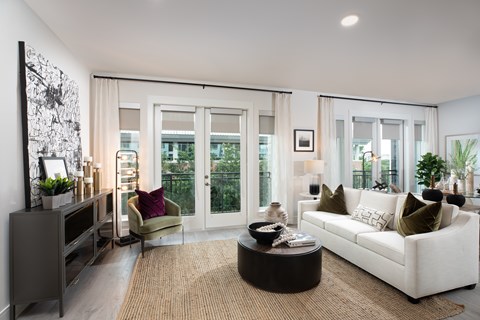 A modern living room with a white sofa, a coffee table, and a large window with curtains.