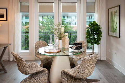 A glass table with four chairs around it.
