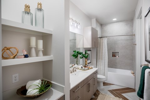 A bathroom with a white counter and a white sink.