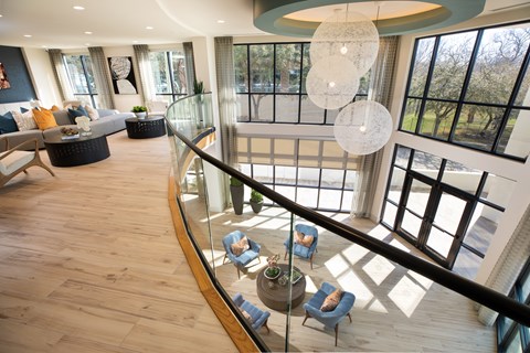 A living room with a glass railing and a large window.