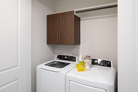 A washing machine and dryer are in a small laundry room.