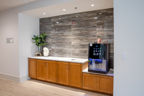 A modern kitchen with wooden cabinets and a stone backsplash.