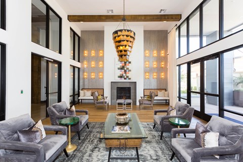 A modern living room with grey couches and a fireplace.