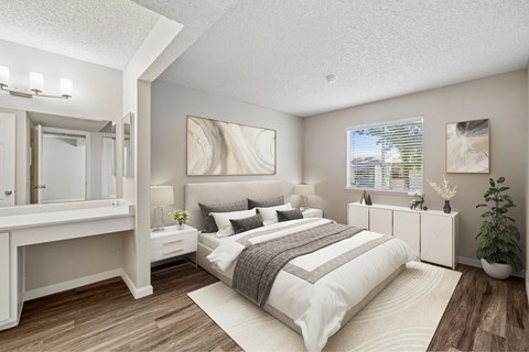 A bedroom with a large bed and a mirrored dresser.
