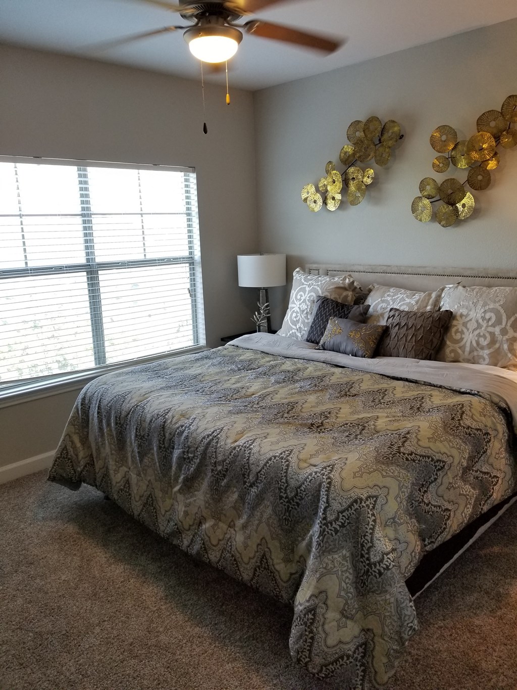 a bedroom with a large bed and a ceiling fan