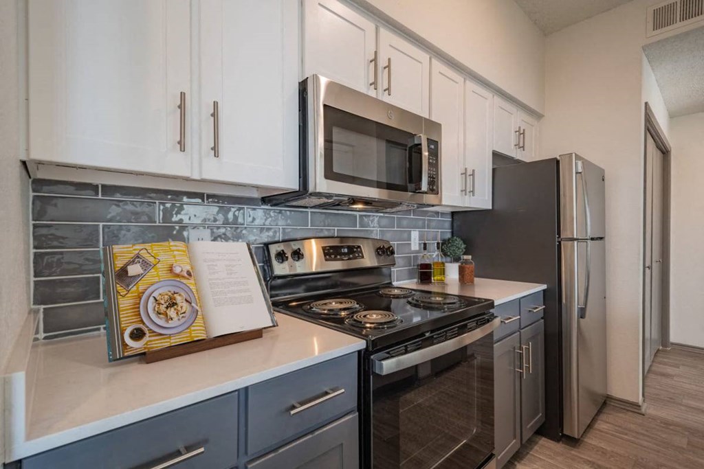 a kitchen with stainless steel appliances and white cabinets