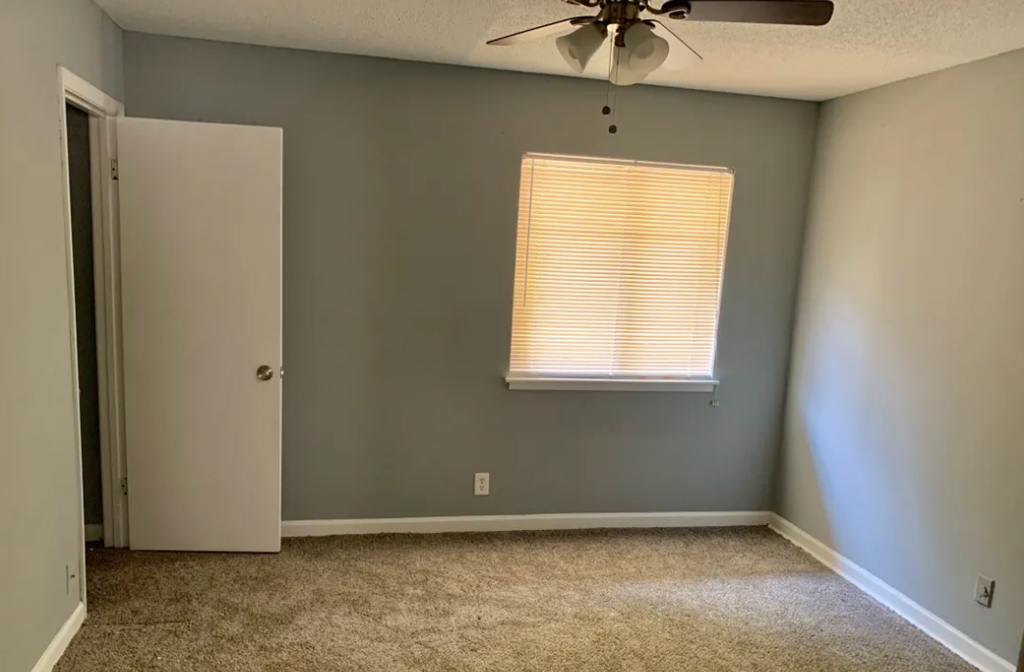 a bedroom with a ceiling fan and a window