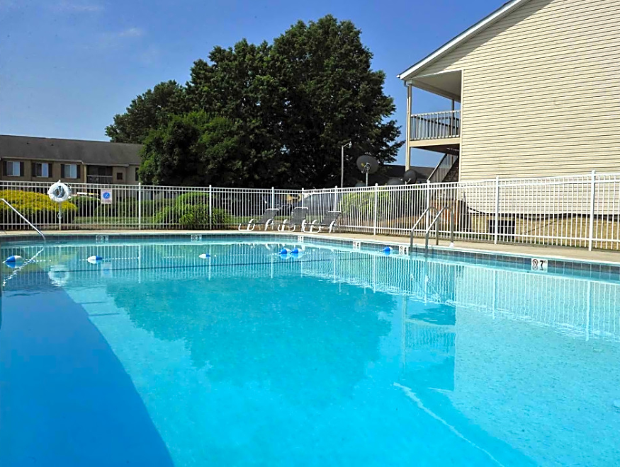 a large pool with a house next to it