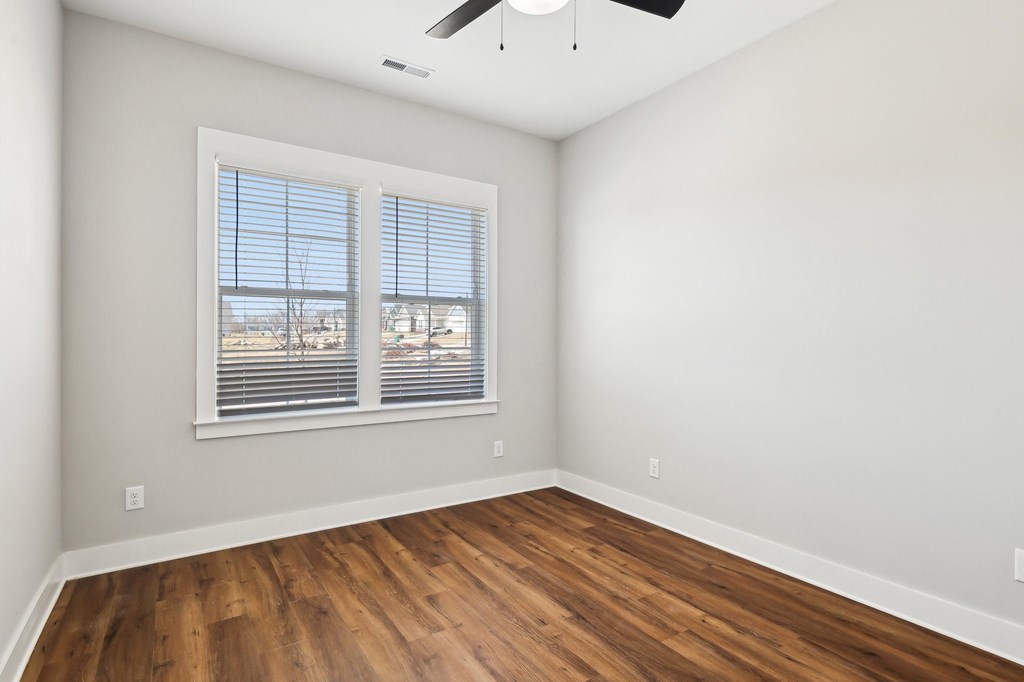 A room with a window and wooden flooring.