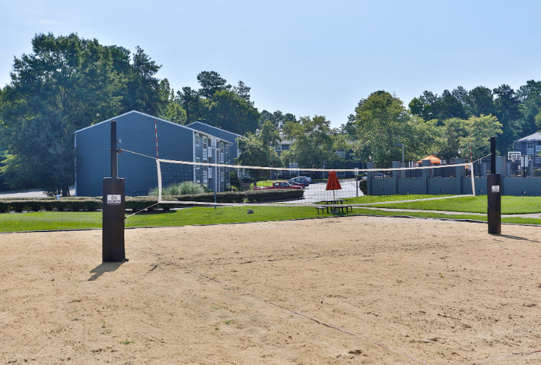 a volleyball court at the whispering winds apartments in pearland, tx