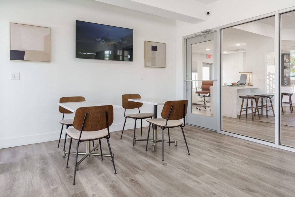 a dining room with a table and chairs and a tv on the wall