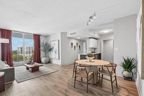 A modern living room with a dining table and chairs.