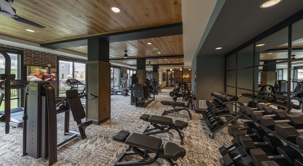 a gym with cardio machines and weights on the floor of a building