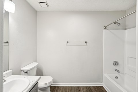 A white bathroom with a toilet, sink, and bathtub.