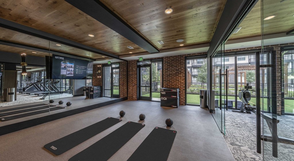 a gym with yoga mats and a tv on the wall