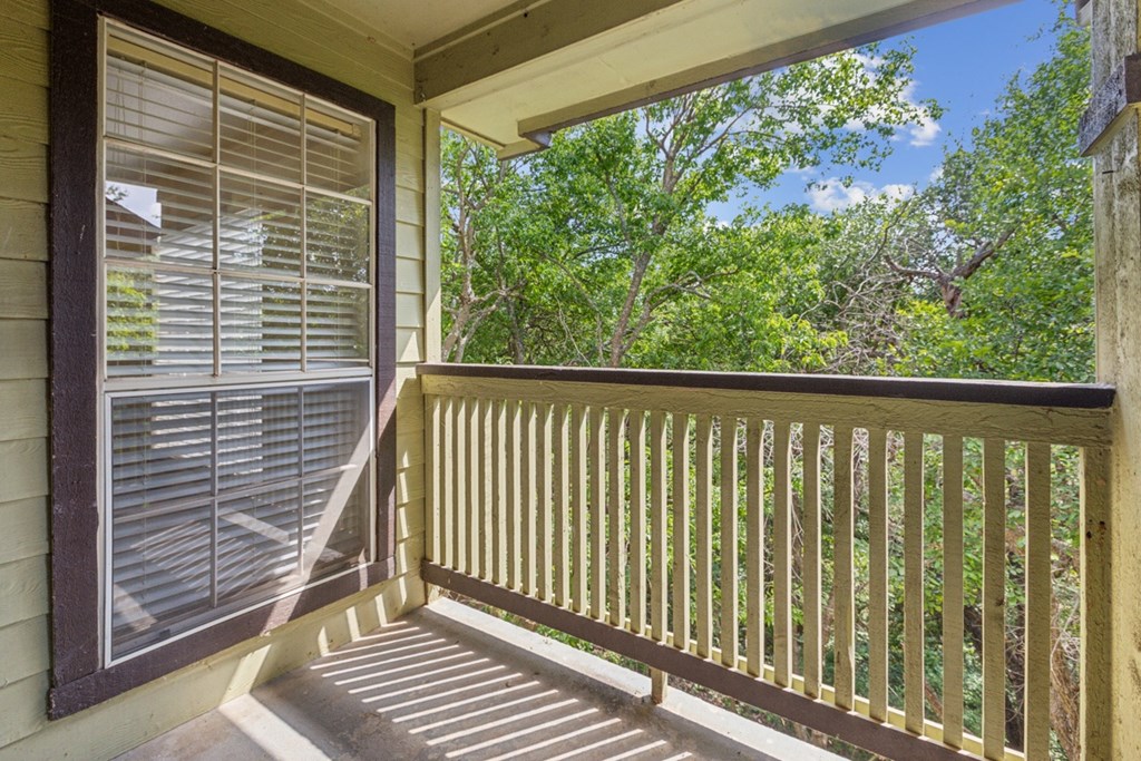 A view from a balcony with a window and a railing.