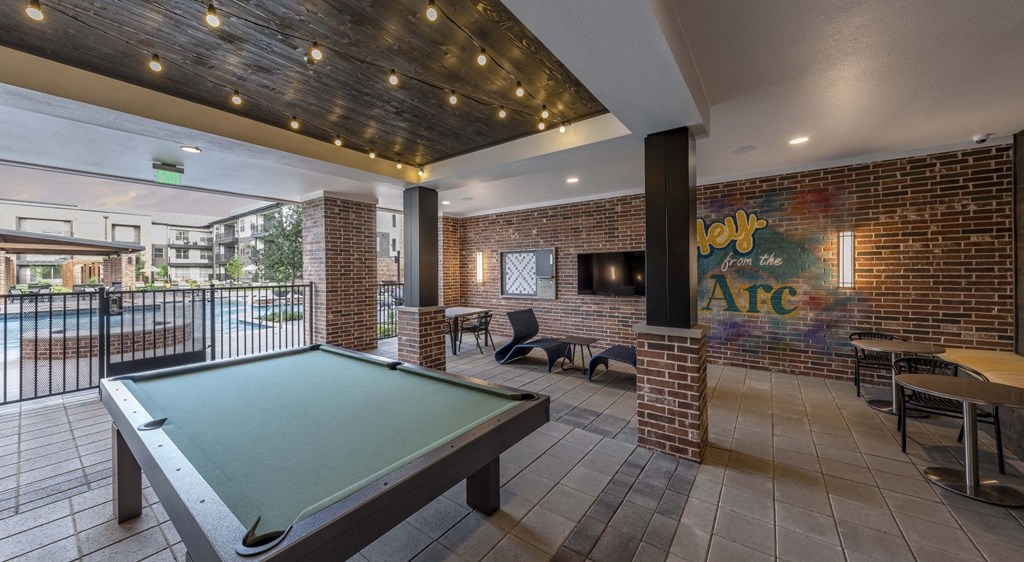a pool table in a clubhouse with a wall with graffiti