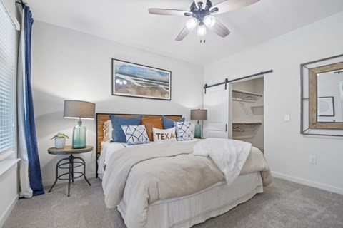 A bedroom with a large bed and a ceiling fan.