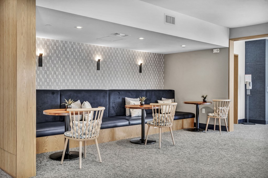 a lounge area with tables and chairs and a blue couch