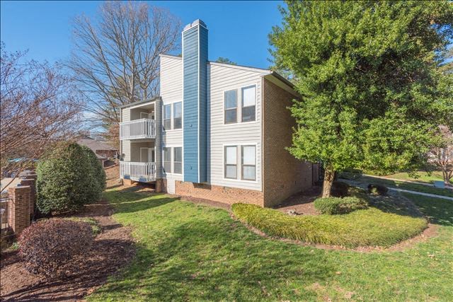 a blue and white apartment building with a tree in front of it