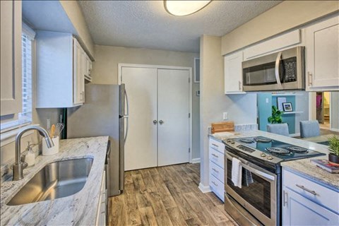 a kitchen with stainless steel appliances and white cabinets