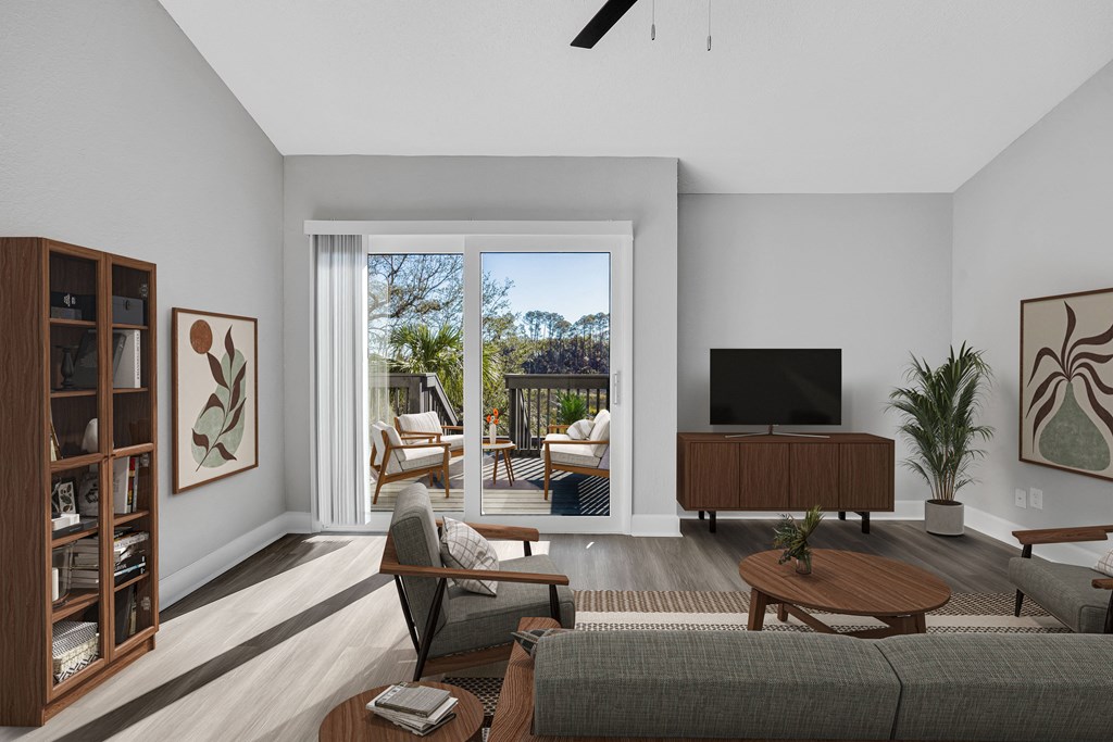 a living room with a couch and a tv and a balcony