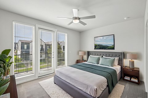 A bedroom with a large bed and a ceiling fan.