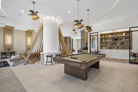 A room with a pool table and a bar area.