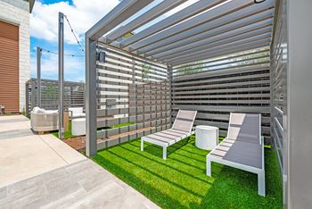 a rooftop patio with lounge chairs and a pergola