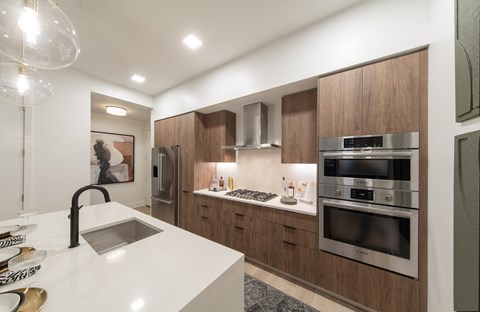 A modern kitchen with wooden cabinets and stainless steel appliances.