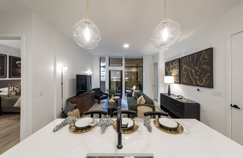 A modern dining room with a white table set for a meal.