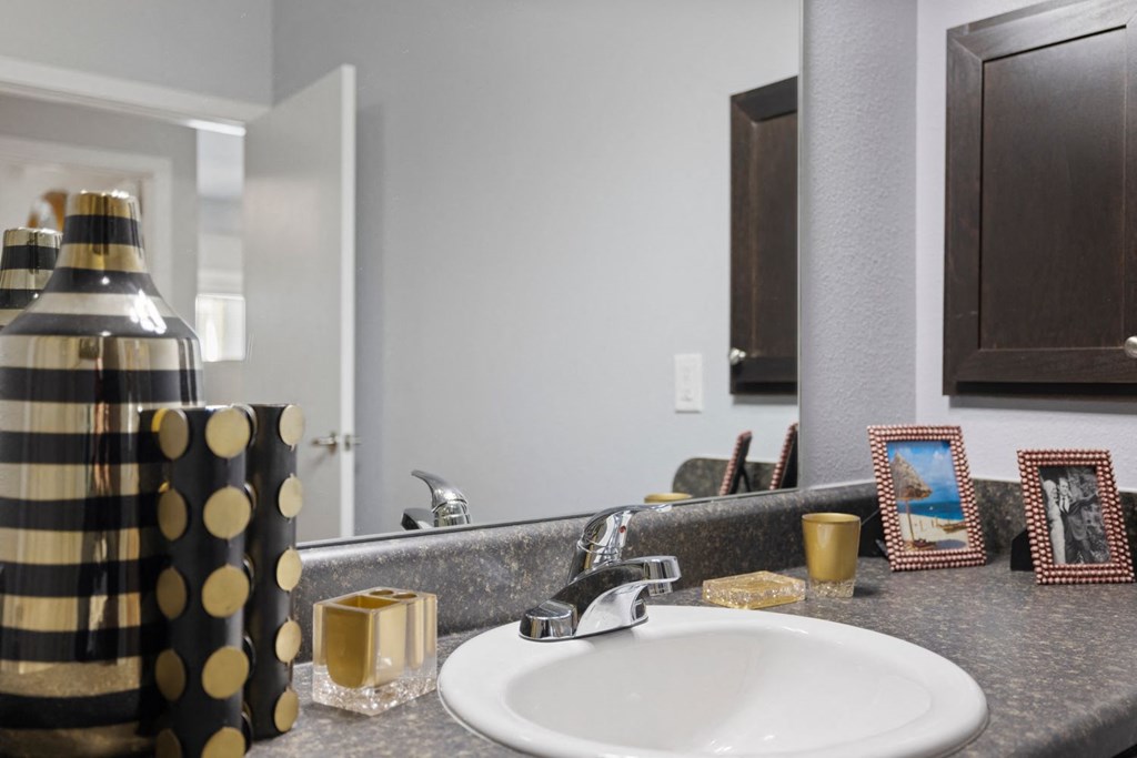A bathroom sink with a striped bottle on the counter.