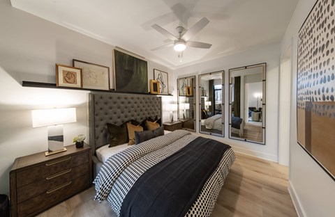 A bedroom with a large bed and a ceiling fan.