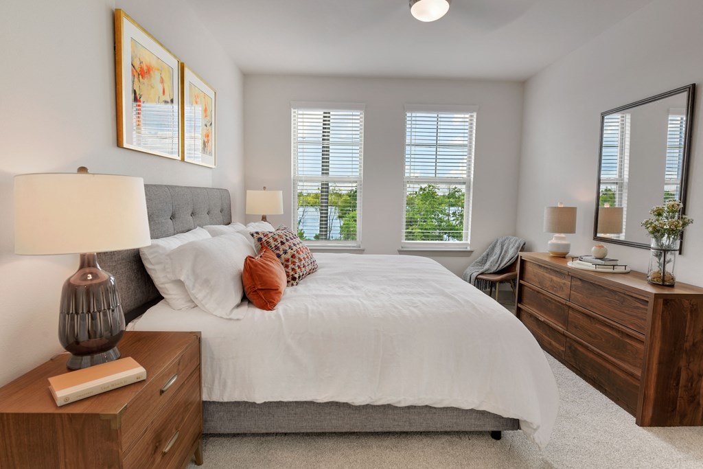 a bedroom with a bed and three windows