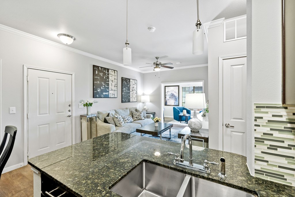A kitchen with granite countertops and a stainless steel sink.
