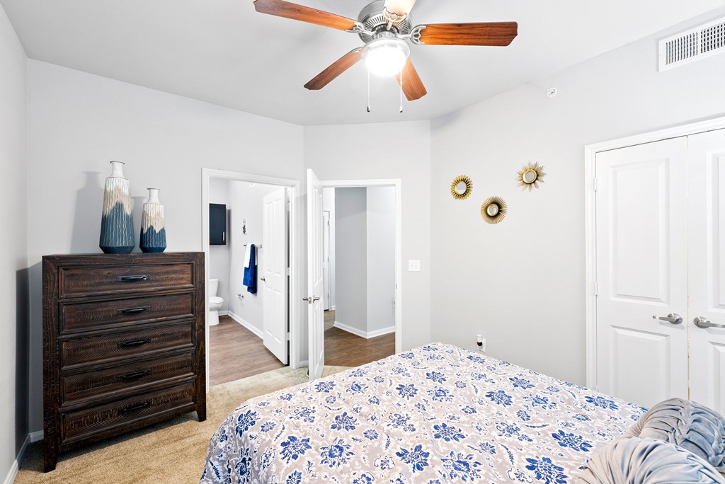 A bedroom with a bed, dresser, and mirror.
