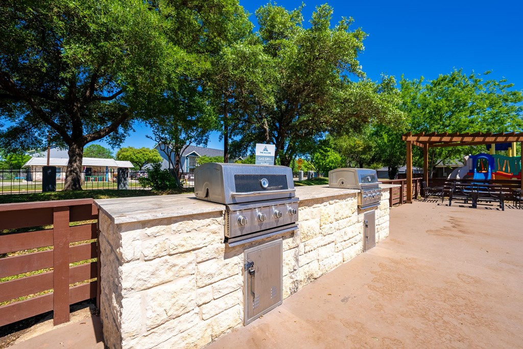A stone wall with a built in BBQ grill.