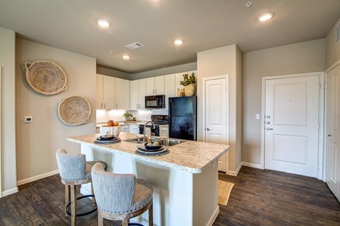 a kitchen with a large island with granite countertops