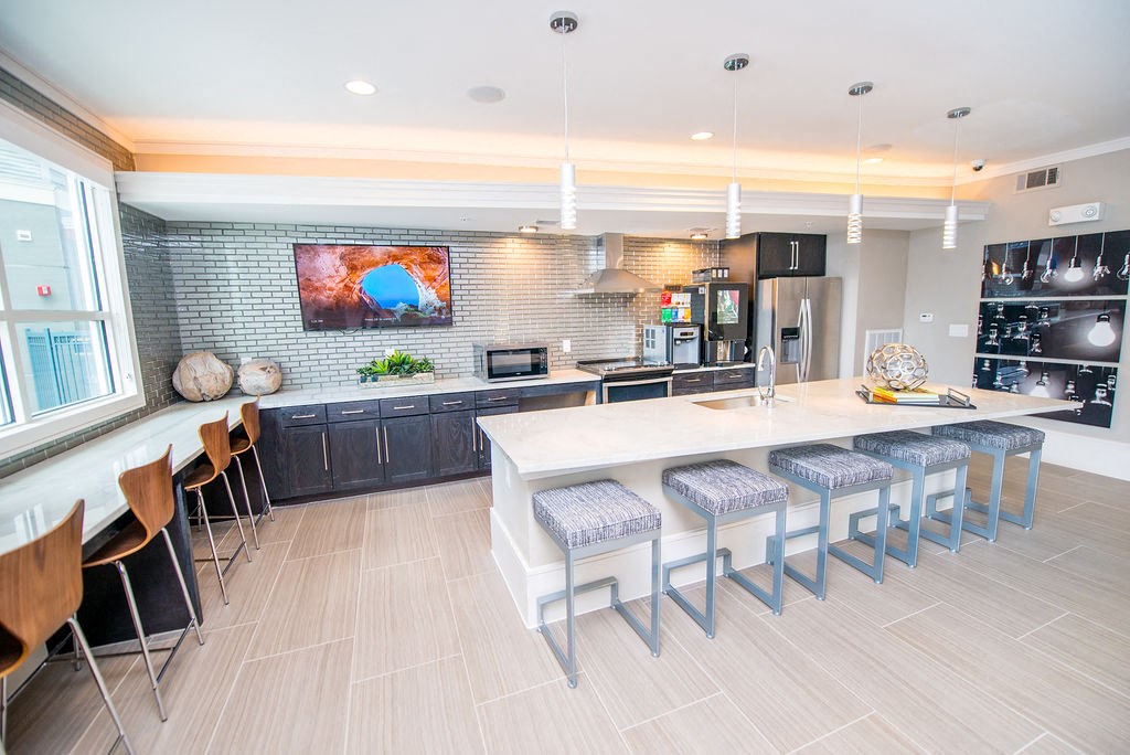 a large kitchen with a long counter and chairs