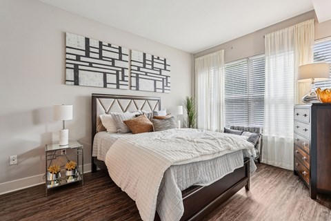 A bedroom with a large bed and a painting on the wall.